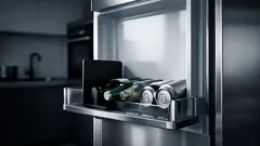 Mit einer Buchstütze im Kühlschrank-Türfach mehr Platz für Flaschen schaffen